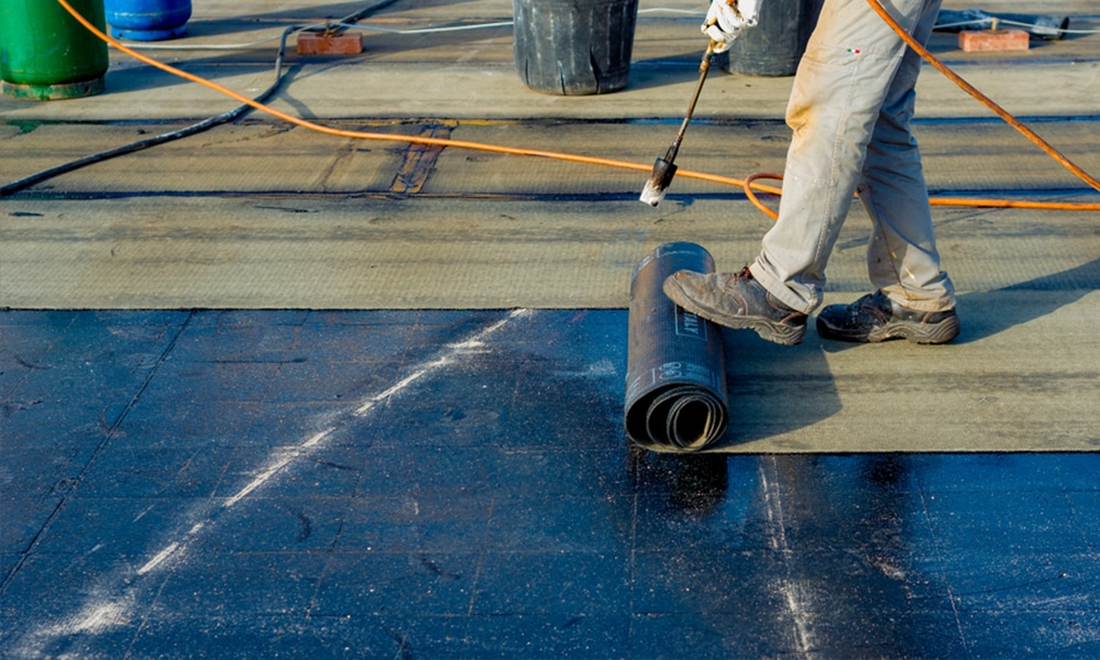 DIY flat roof repair tips showing essential tools like roof sealant, waterproof tape, EPDM patch kits, and safety gear